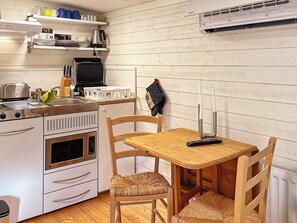 A compact kitchen with a microwave, toaster, and kettle on the countertop. - 5 Star Holiday Home in Bjorko (Björkö)