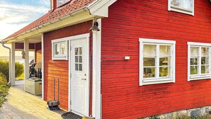 A red house with a porch, a door, and two windows. - 5 Star Holiday Home in Bjorko (Björkö)