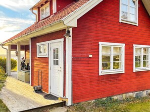 A red house with a porch, a door, and two windows. - 5 Star Holiday Home in Bjorko (Björkö)