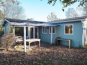 A single-story house with a covered patio area, a small table, and a bench. - 4 Person Holiday Home in Jaegerspris (Jægerspris)