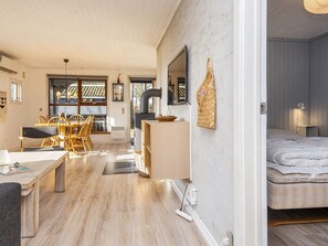 A modern interior with a dining area, a kitchenette, and a bedroom.