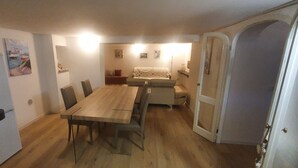 Una cocina funcional con una mesa de comedor de madera, sillas, un refrigerador y un sofá.