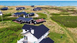 A coastal residential area with houses, some with attached garages, and a clear view of the sea. - 4 Star Holiday Home in Hjorring (Hjørring)
