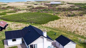 A modern house with a flat roof, a patio, and a view of the sea.