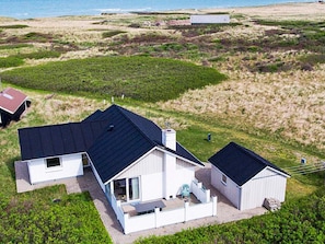 A modern house with a flat roof, a patio, and a view of the sea. - 4 Star Holiday Home in Hjorring (Hjørring)