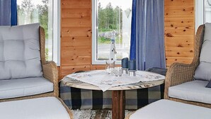 A cozy corner with wicker furniture, a round table, and a view of the outdoors. - 6 Person Holiday Home in Meloy (Meloy)