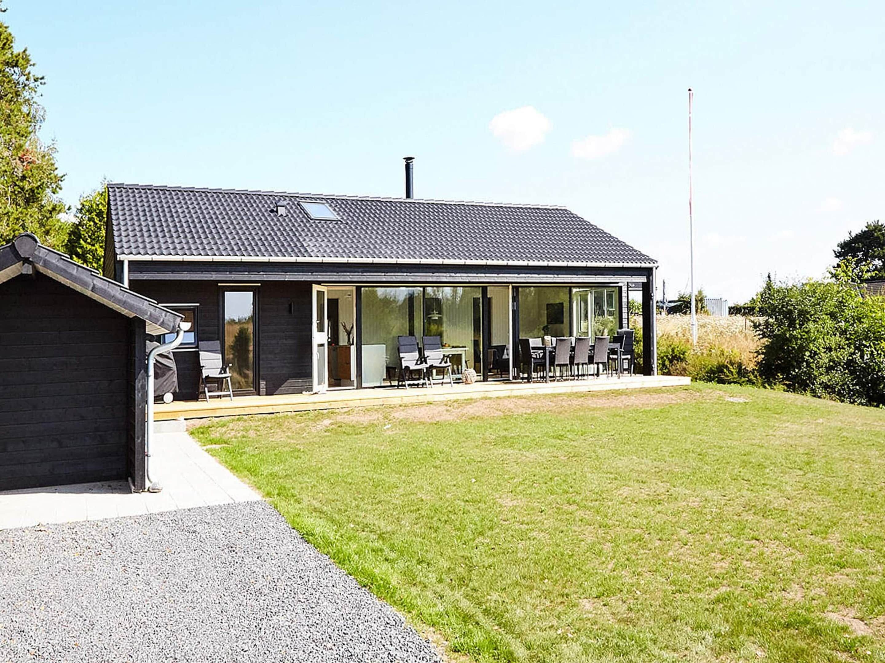 A modern house with a patio, a covered outdoor seating area, and a visible chimney.