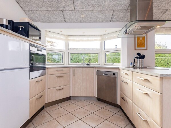 A modern kitchen with a dishwasher, oven, and microwave.