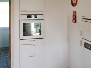 Una cocina con horno empotrado y refrigerador.
