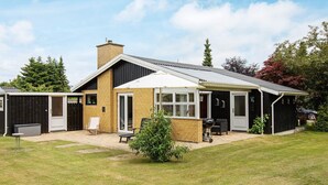 A modern house with a covered patio, a garage, and a fenced yard. - 5 Person Holiday Home in Vaeggerlose (Vaeggerlose)