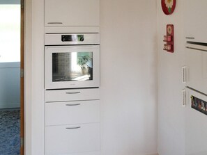 A kitchen with a built-in oven and a refrigerator. - 5 Person Holiday Home in Vaeggerlose (Vaeggerlose)