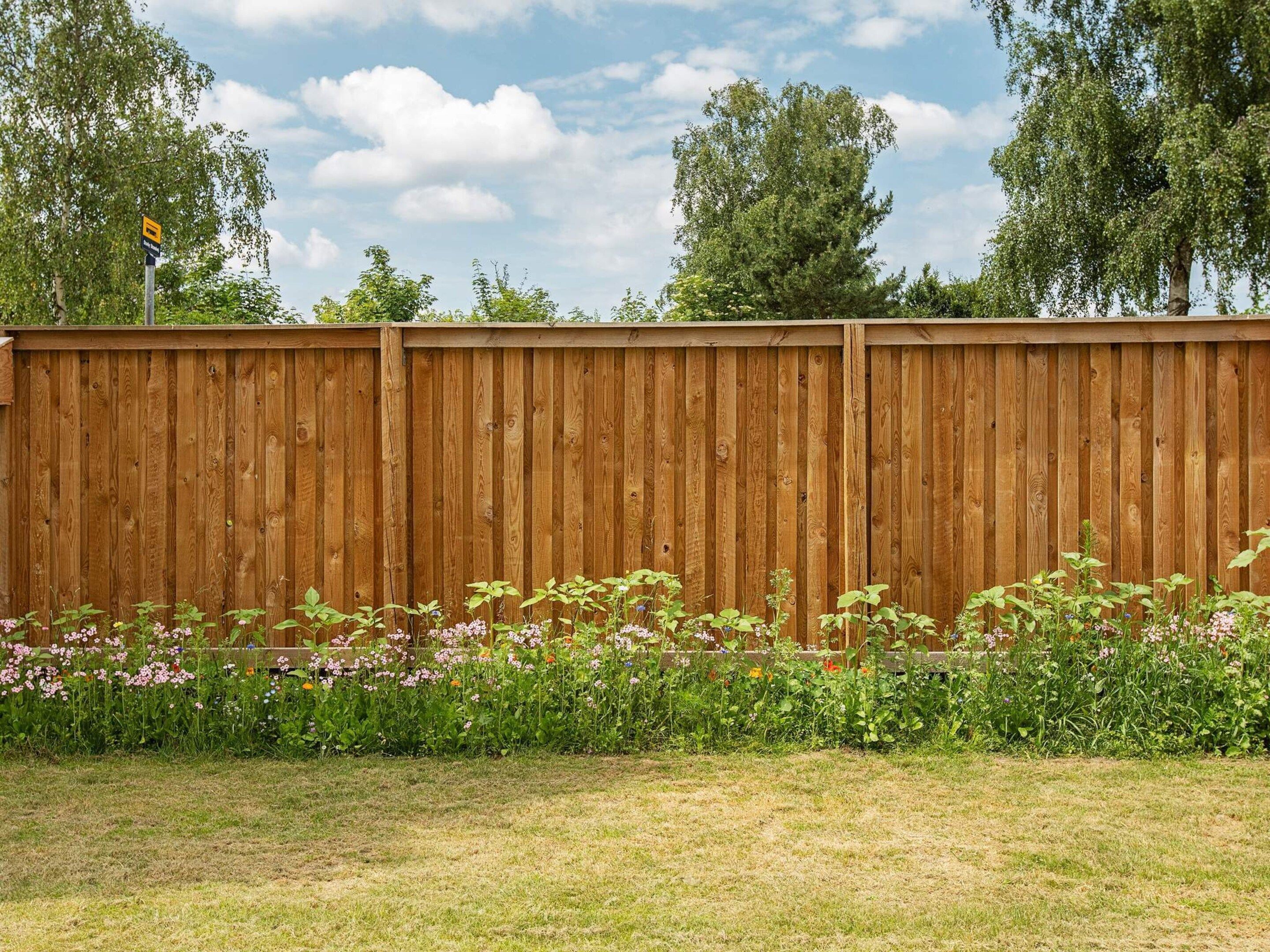 A wooden fence with a grassy area in front.