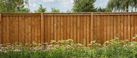 A wooden fence with a grassy area in front.