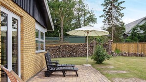 Een terras met tuinmeubilair, een houten schutting en een stenen muur.