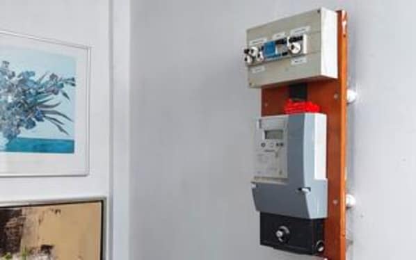 A wall-mounted electrical panel with a control panel and a switchboard.