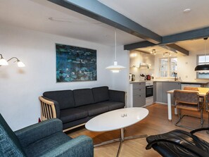 A modern living room with a sofa, a round table, and a painting on the wall. - 4 Person Holiday Home in Rudkobing (Rudkobing)
