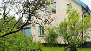 A two-story house with a sloped roof, a visible chimney, and a blue door. - 7 Person Holiday Home in Hova (Hova)