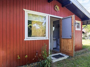 A red wooden building with a door leading to a bathroom. - 5 Person Holiday Home in Bogo By (Bogø By)