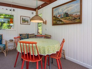 A dining area with a round table, red chairs, and a green tablecloth. - 4 Person Holiday Home in Ans By (Ans)