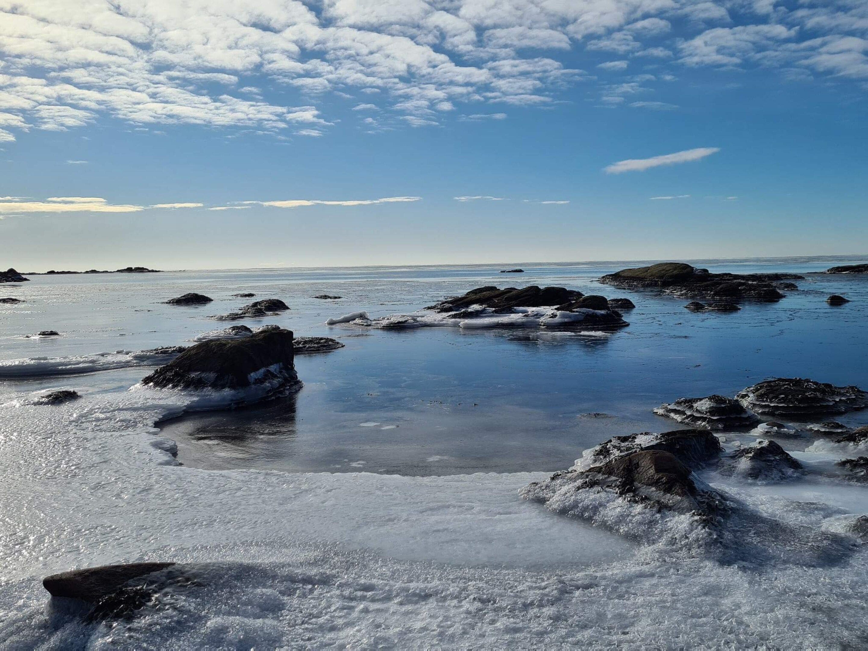 Un paysage côtier caractérisé par des formations rocheuses et une eau calme.