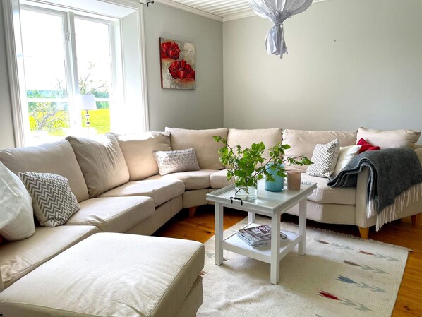 Una sala de estar con un sofá modular, una mesa de centro y una planta.
