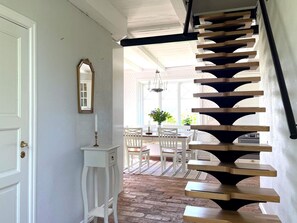 Una escalera de madera con soportes negros que conduce a un piso superior.