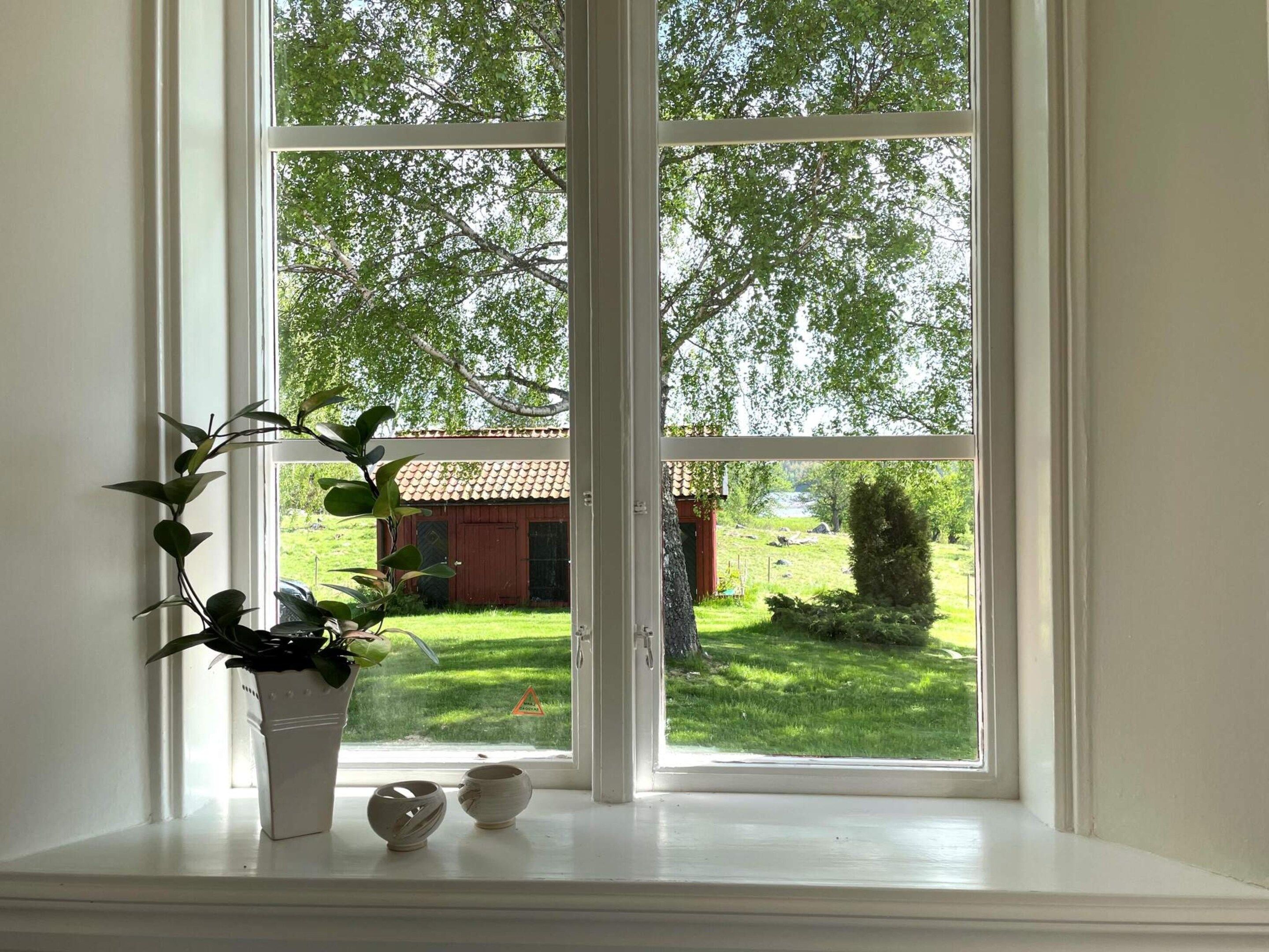 Een uitzicht op een groen landschap en een gebouw met een rood dak.