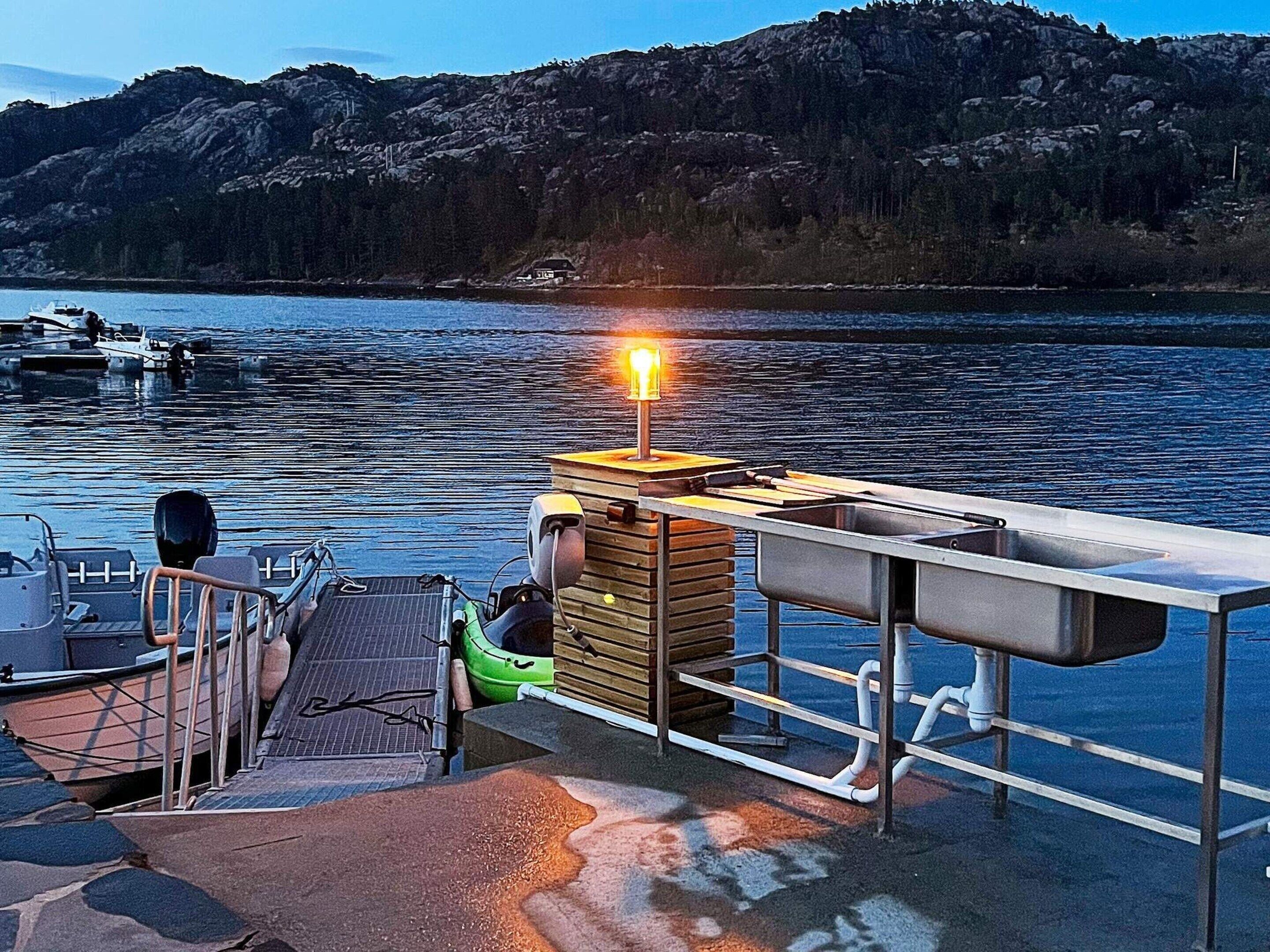 Un muelle con un bote, un kayak y una estructura de madera con una luz.