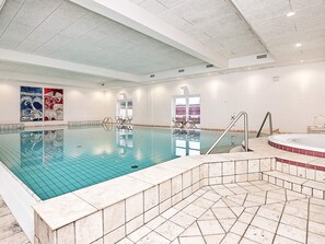 An indoor swimming pool with a tiled floor, a hot tub, and a seating area with chairs. - 5 Star Holiday Home in Skagen (Skagen)