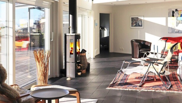 A spacious living area with a modern fireplace, comfortable seating, and large windows. - 10 Person Holiday Home in Bua (Bua)