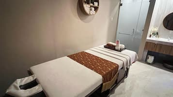 Comfortable room with a neatly made bed, a wall-mounted shelf, and a contemporary bathroom.