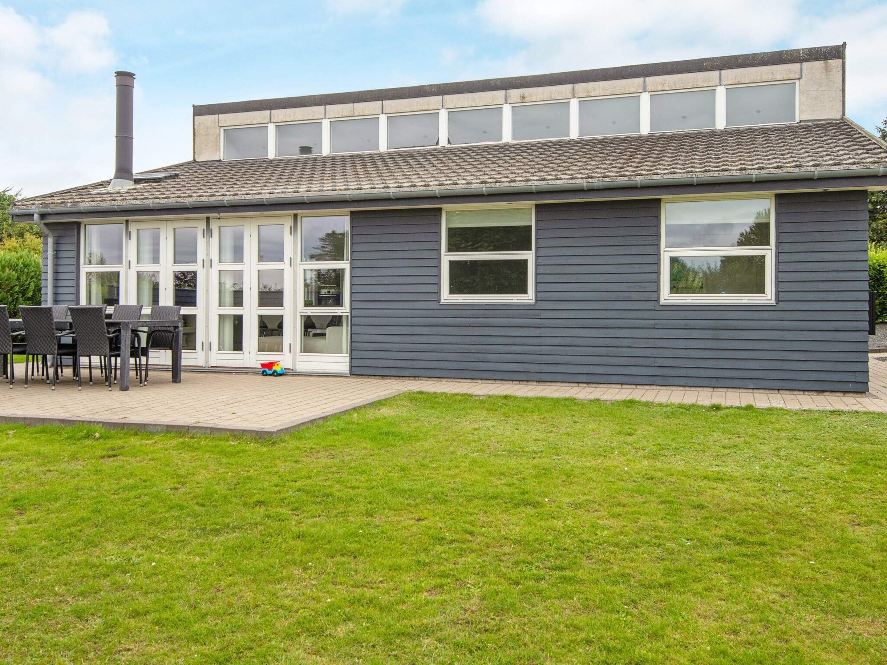 Een gebouw met twee verdiepingen en een terras met tuinmeubilair.
