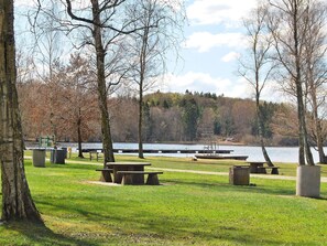 A park with picnic tables, benches, and a lake view. - 7 Person Holiday Home in Vankiva (Vankiva)