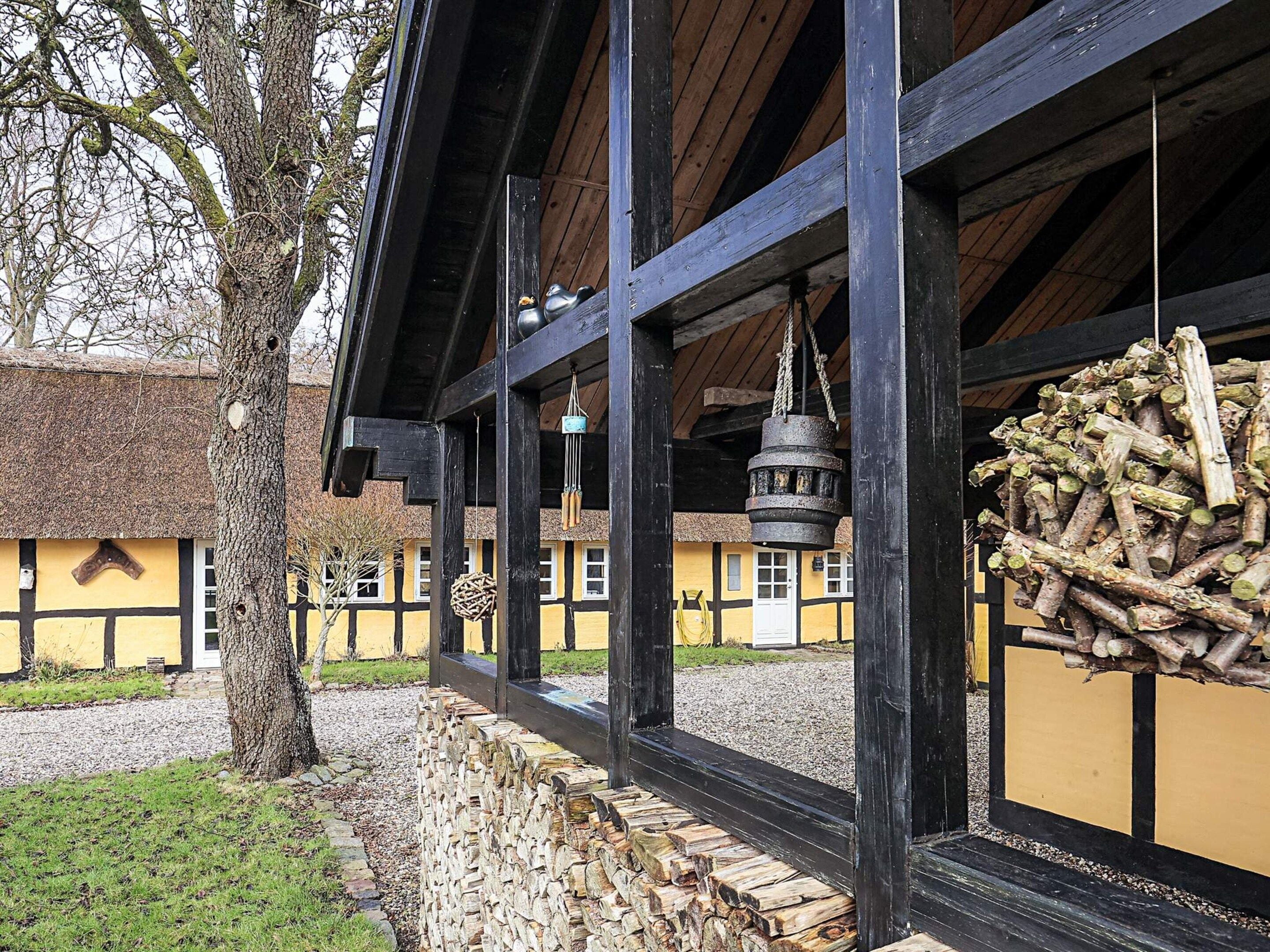A traditional building with a thatched roof, wooden beams, and a hanging bell.