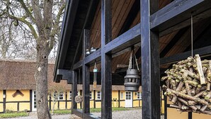 A traditional building with a thatched roof, wooden beams, and a hanging lantern. - 4 Person Holiday Home in Asaa (Asaa)