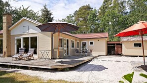 A two-story cabin with a patio area, outdoor seating, and a covered section. - 4 Star Holiday Home in Nexo (Nexø)