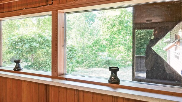 A room with wooden paneling and large windows offering views of a green landscape. - 4 Person Holiday Home in Aakirkeby (Akirkeby)