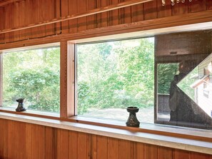 A room with wooden paneling and large windows offering views of a green landscape. - 4 Person Holiday Home in Aakirkeby (Akirkeby)