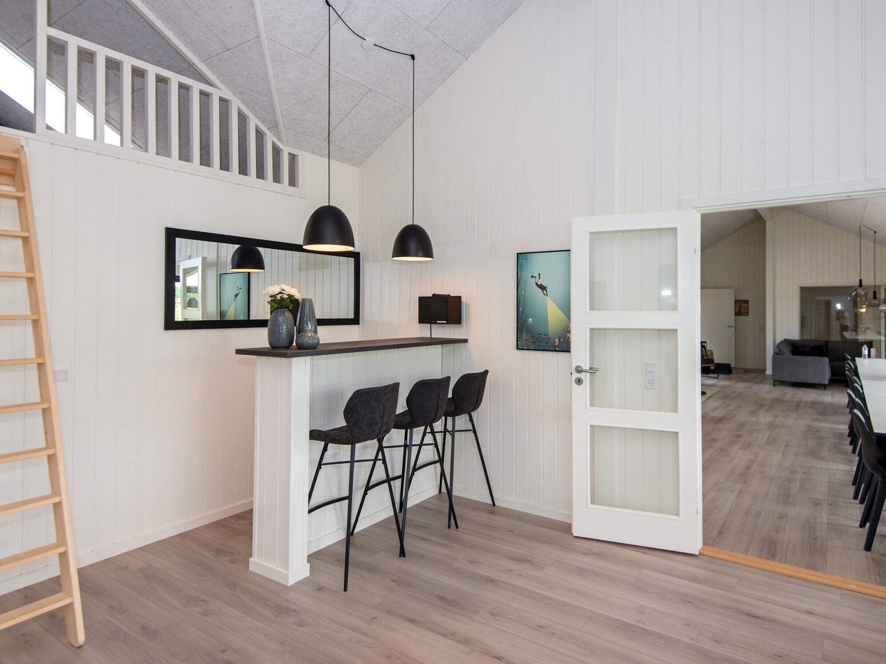 Ein modernes Interieur mit Küchenbereich, Essbereich und offener Wohnfläche.
