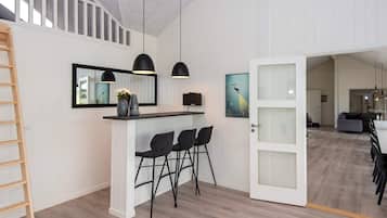 Ein modernes Interieur mit Küchenbereich, Essbereich und offener Wohnfläche.