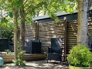 Un espacio al aire libre con sillas de mimbre y una terraza de madera.