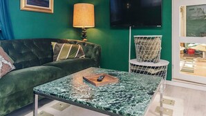 A green-themed living room with a sofa, a coffee table, a lamp, a TV, and a chair. - 8 Person Holiday Home in Gilleleje-by Traum (Gilleleje)