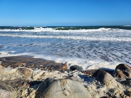 A rocky beach with waves crashing onto the shore.