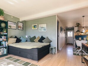 Une chambre spacieuse avec un grand lit, une bibliothèque et un coin bureau.