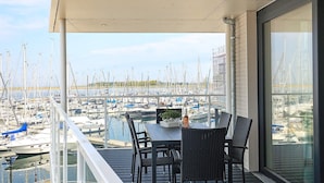 A balcony with a table and chairs overlooking a marina with numerous boats. - 5 Star Holiday Home in Wendtorf (Wendtorf)