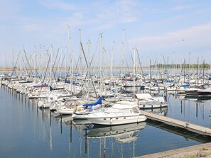Ein Yachthafen mit zahlreichen Booten, die an Holzstegen festgemacht sind.