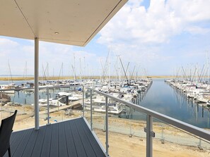 A marina with boats docked in calm water, a covered deck area, and a clear sky. - 5 Star Holiday Home in Wendtorf (Wendtorf)