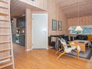 A wooden interior with a kitchen, a sofa, a dining table, and a window with blinds. - 4 Star Holiday Home in Ulfborg (Ulfborg)