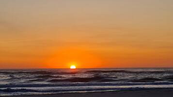 A sunset over the ocean with waves.