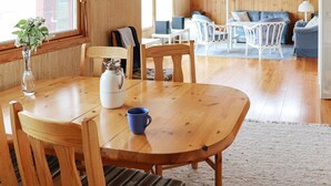 A cozy wooden interior with a dining table, chairs, a coffee pot, and a vase with flowers. - 5 Person Holiday Home in Glommen-by Traum (Glommen)